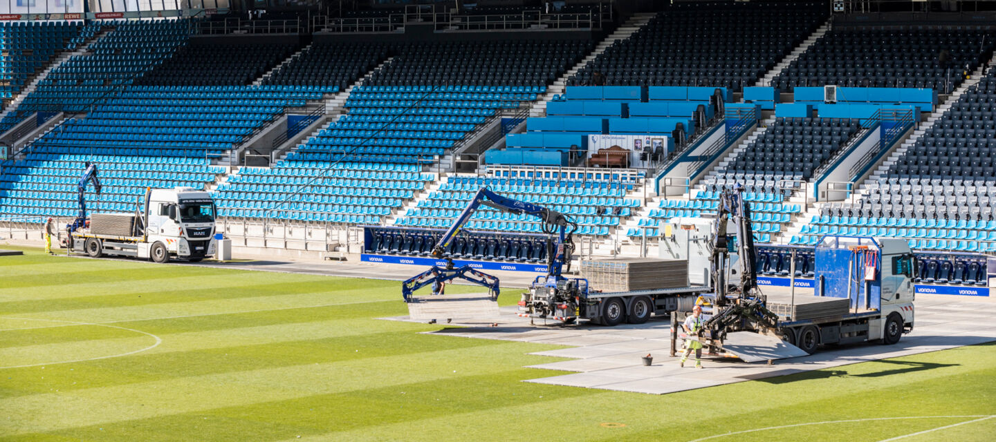 Cteam installation work at a stadium using cranes to place field panels. Cteam installation work at a stadium using cranes to place field panels.