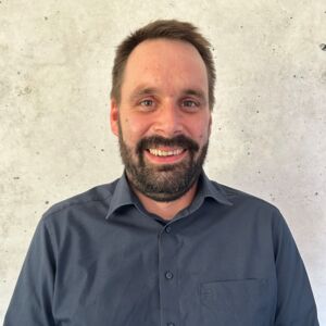 Mitarbeiter von Cteam Consulting und Anlagenbau lächelt, Experte für Infrastrukturlösungen.