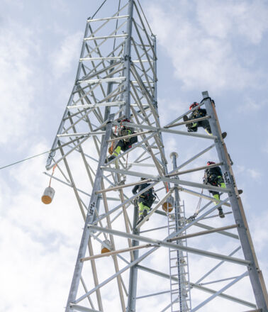 Cteam teams working high on a power transmission tower for infrastructure construction. Cteam teams working high on a power transmission tower for infrastructure construction.
