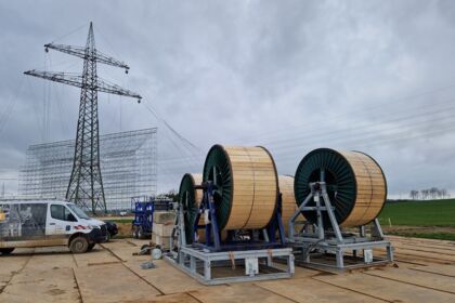 Cteam Freileitungsbau: Hochspannungsleitung mit Mast, Gerüst und Kabeltrommeln bei der Montage. Cteam Freileitungsbau: Hochspannungsleitung mit Mast, Gerüst und Kabeltrommeln bei der Montage.