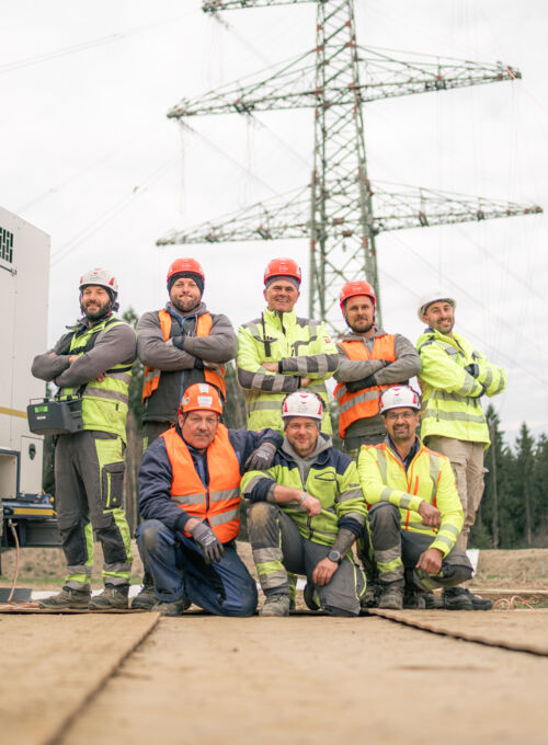 Cteam: Starkes Team von Fachleuten vor einem Strommast. Ihr Partner für Energieinfrastruktur.