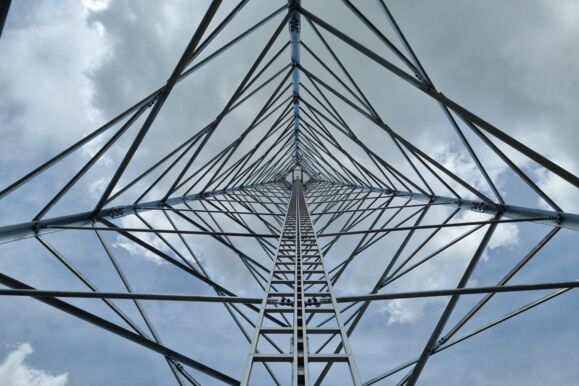 Blick von unten in die robuste Struktur eines Cteam Gittermastes für Telekommunikation oder Strom.