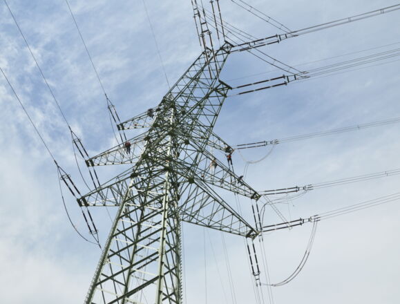 Cteam : Équipe travaillant sur une ligne électrique haute tension pour maintenance et réparation.