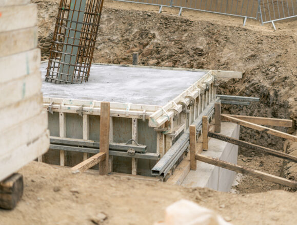 Fundamentarbeiten im Ingenieurbau: Schalung, Beton und Bewehrung auf Baustelle.