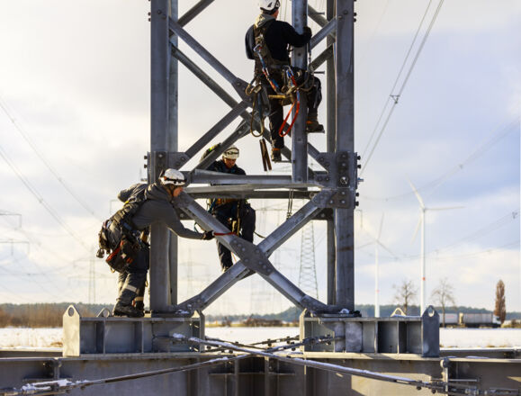 Sicherer Freileitungsbau: Cteam Mitarbeiter arbeiten auf Strommasten. Sicherer Freileitungsbau: Cteam Mitarbeiter arbeiten auf Strommasten.