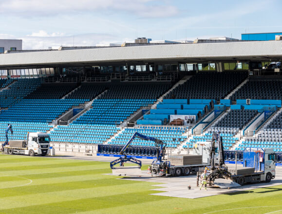Cteam installation work at a stadium using cranes to place field panels. Cteam installation work at a stadium using cranes to place field panels.