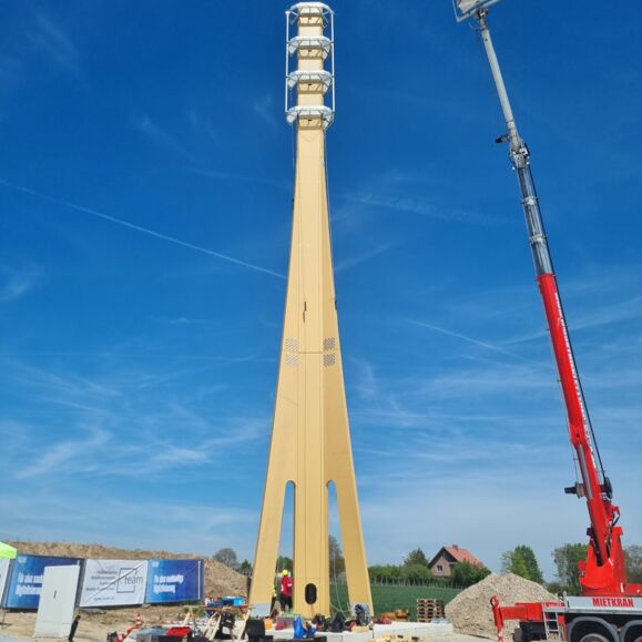 Cteam Consulting und Anlagenbau: Errichtung eines hohen Mastes mit Kran unter blauem Himmel. Cteam Consulting und Anlagenbau: Errichtung eines hohen Mastes mit Kran unter blauem Himmel.