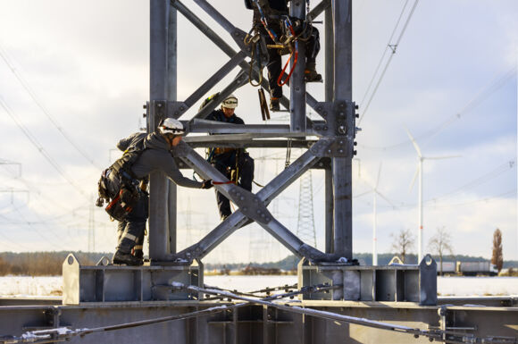 Sicherer Freileitungsbau: Cteam Mitarbeiter arbeiten auf Strommasten. Sicherer Freileitungsbau: Cteam Mitarbeiter arbeiten auf Strommasten.