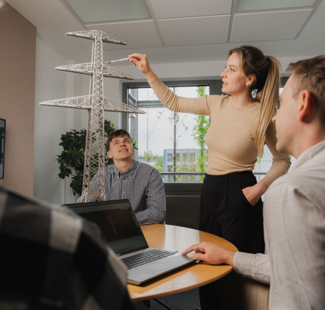 Engenheiros da Cteam discutem modelo de torre de transmissão, demonstrando soluções de engenharia e inovação. Engenheiros da Cteam discutem modelo de torre de transmissão, demonstrando soluções de engenharia e inovação.