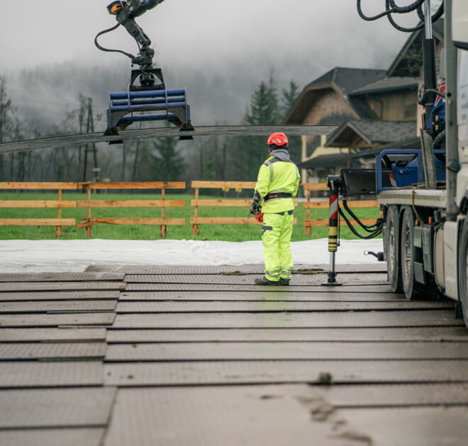 Trabalhadores da Cteam supervisionam a colocação de painéis em área de construção com maquinário. Trabalhadores da Cteam supervisionam a colocação de painéis em área de construção com maquinário.