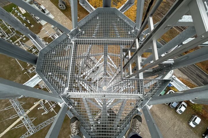 Arbeit auf Höhe: Blick von einem Cteam-Gitterrost-Podest auf Stromleitungs-Infrastruktur.